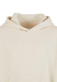 Beige bomull hettegenser med sn�øring, en frontlomme og et mykt, teksturert stoff. Designet med normal passform og en enkel krage.