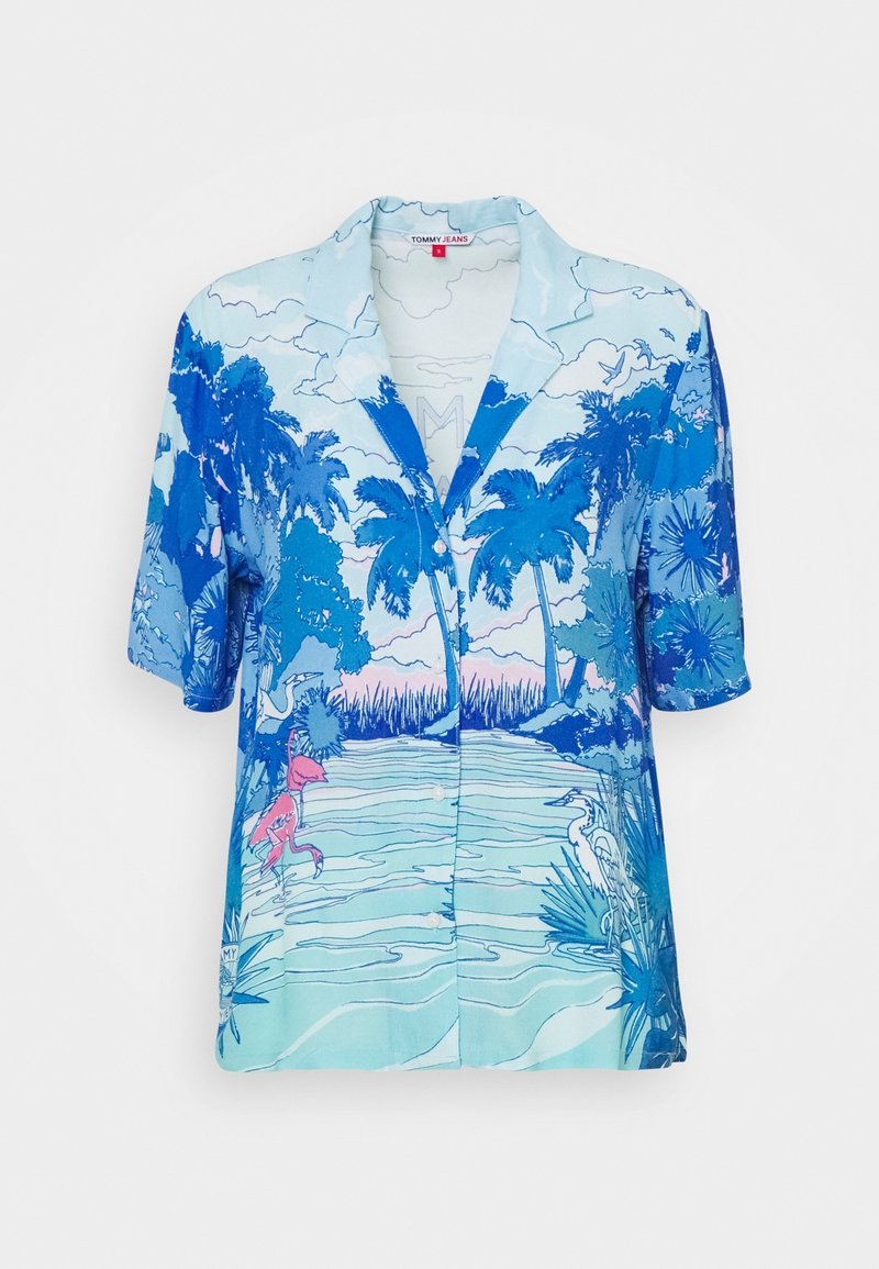 Camisa de botones de manga corta en tonos de azul con una escena tropical que presenta palmeras, agua y gráficos de flamencos.