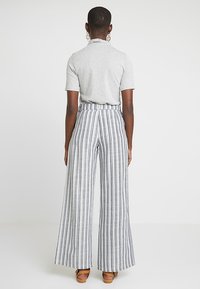 Randiga vida byxor i vitt och blått, tillverkade av lättviktsmaterial, med hög midja och avslappnad passform.