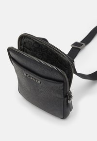 Borsa a tracolla in pelle nera con superficie texture, chiusura con zip, tasca frontale e interno con rivestimento a motivo logo. Cinghia regolabile.