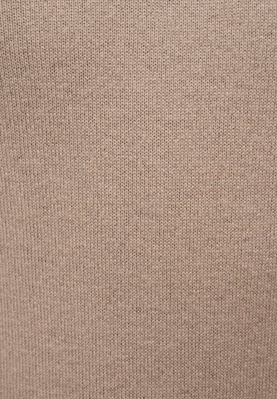 Μπεζ πλεκτό ύφασμα με απλό, σφιχτό σχέδιο ραφής που δημιουργεί μια ομαλή, ομοιόμορφη υφή.