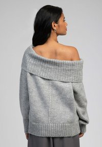 Pull en tricot décolleté en gris clair, avec un col et des poignets côtelés, une coupe ample et un tissu texturé au toucher doux.