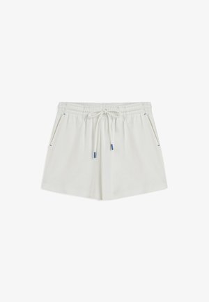 Shorts blancs légers avec une taille élastique, cordon de serrage ajustable et poches latérales avec des accents bleus. Texture lisse.