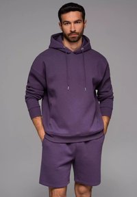 Lila Hoodie- und Shorts-Set aus weichem Stoff. Verfügt über eine Kapuze mit Kordelzug, gerippte Bündchen und eine lockere Passform für hohen Tragekomfort.