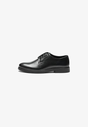 Black leather lace-up shoe with a rounded toe, smooth texture, minimal stitching, and a low rubber heel for stability.