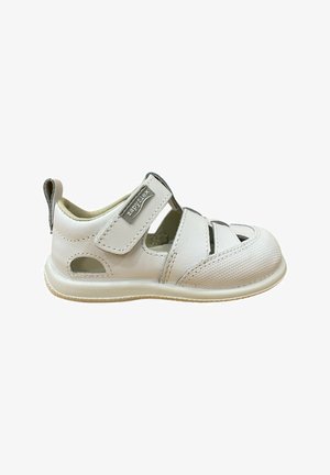 Sandalia para niño pequeño de color blanco con puntera cerrada, correa de velcro etiquetada "zapyflex", recortes laterales y suela acolchada suave.