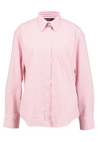 Proužkovaná košile na knoflíky v světle růžové a bílé barvě. Má límeček, dlouhé rukávy a náprsní kapsu. Vyrobena z hladké látky.