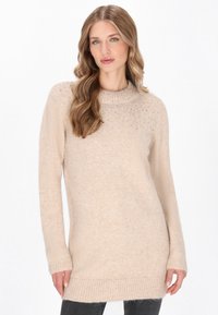 Maglione a maniche lunghe color beige chiaro con orlo e collo a costine, con accenti scintillanti sottili sulle spalle e una finitura morbida e testurizzata.