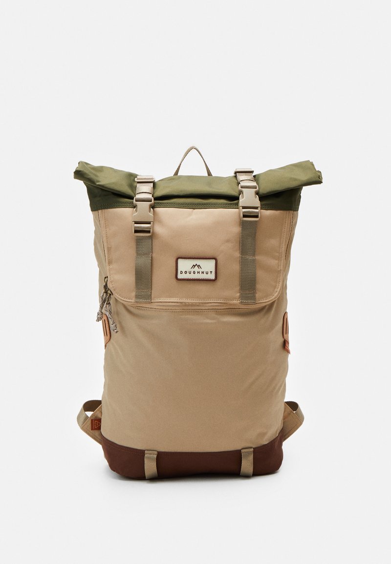 Zaino con chiusura roll-top, realizzato in materiali beige e verde oliva, dotato di spallacci regolabili, doppie fibbie laterali e una tasca frontale con zip.
