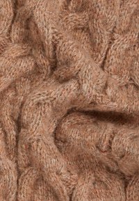 Tissu tricoté en marron doux et chaud avec un motif texturé en câbles. Le matériau semble flou et confortable, mettant en valeur un effet mélangé subtil.