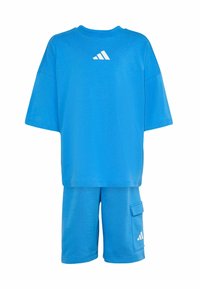 Modrá bavlnená tričko s krátkymi rukávmi a bielym logom Adidas. Zodpovedajúce modré šortky s bočnou kapsou a detailom bieleho loga.