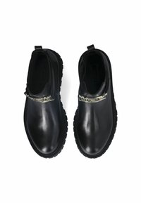 Zwarte leren instappers met een glanzende afwerking, voorzien van een ronde neus en een decoratieve zilveren kettingaccent aan de voorkant. Geribbelde rubberen zool.