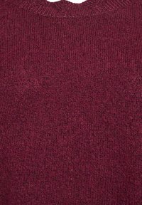 Nahaufnahme eines bordeauxrot gestrickten Stoffs mit einer gerippten Textur und einem runden Halsausschnitt.