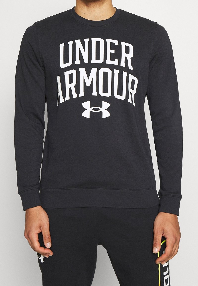 Felpa nera con grande testo bianco "UNDER ARMOUR" e logo sul davanti. Presenta un collo rotondo e polsini e orlo a coste.