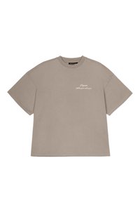 Korte ermer, oversized beige t-skjorte laget av bomull, med en liten brodert tekst på venstre brystområde. Myk tekstur, uformelt design.