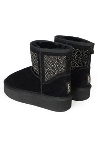 Botines negros de ante con un lado texturizado y adornos, un forro suave y una suela de goma plana.