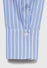 Blue and white vertically striped shirt cuff with a single white button fastened, showing detailed stitching and fabric texture.