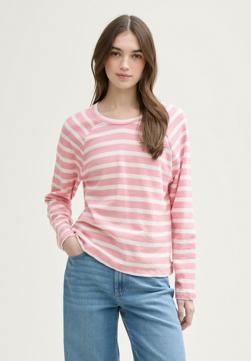 Camisa de manga larga ligera a rayas rosa y blancas, con un cuello redondeado y una tela suave. Combinada con jeans de mezclilla azul.