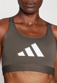 adidas Performance POWERREACT BIG LOGO GRAPHIC BRA - Lengvai krūtinę prilaikanti sportinė liemenėlė - shadow olive