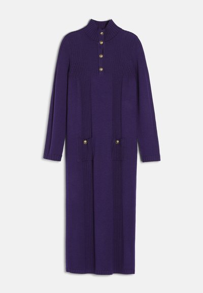Longue robe en maille violette à manches longues, lignes verticales côtelées, col montant, avec quatre boutons dorés sur la poitrine et deux sur les poches avant.