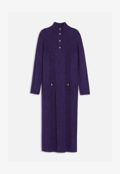 Longue robe en maille violette à manches longues, lignes verticales côtelées, col montant, avec quatre boutons dorés sur la poitrine et deux sur les poches avant.
