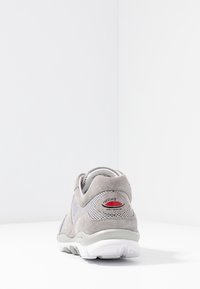 Graue Wildleder- und Mesh-Sport-Schuhe mit abgerundetem Rücken, weißer Sohle und rotem Akzentlogo, das mit "rolling sensitive" beschriftet ist.