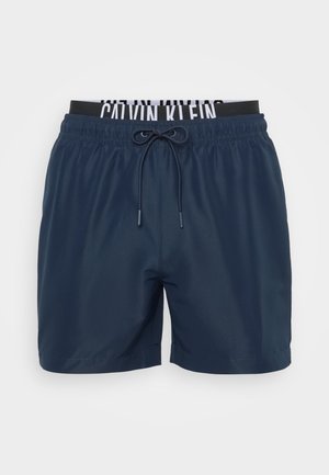 Shorts de înot bleumarin dintr-un material ușor, cu un tiv elastic și un șnur de contrast. Au un tiv personalizat și o textură netedă.