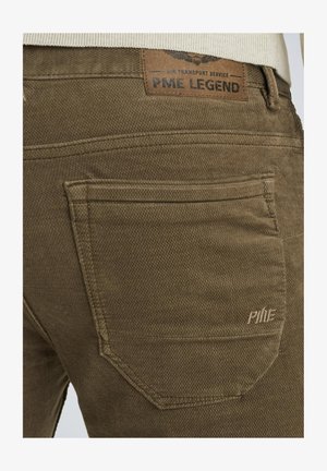 Hnedé bavlnené nohavice s textúrovanou tkaninou, charakteristickým prešitím zadných vreciek a koženým štítkom s označením "PME LEGEND."