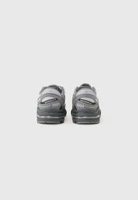 Scarpe da ginnastica grigie con tomaia in rete, soletta ammortizzata e dettagli testurizzati. Presenta il marchio "New Balance" e "1000" sul tallone.