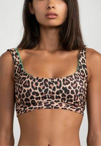 Crop top in stampa leopardata con scollatura rotonda e spalline larghe, caratterizzato da una fodera interna verde in contrasto. Tessuto morbido e liscio.