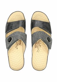 Černé sandály s křížovými popruhy, texturovaným černým akcentem, zaoblenou špičkou a polstrovanou béžovou stélkou. Obsahují kulatou černou knoflíkovou ozdobu.