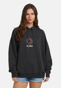 Czarna, oversize hoodie z kieszenią kangurzą z przodu, z haftowanym wzorem promieni słonecznych i nazwą marki. Wykonana z miękkiego materiału.