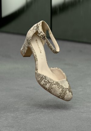 Cream and brown snake-print high heel shoe with an ankle strap and pointed toe design, featuring a textured upper and a modest block heel.