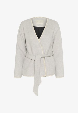 Helehall soe jakk, mis on valmistatud pehmest kangast, V-kaeluse, pikkade varrukate, sidevööga ja kreemivärvi õmblustega äärtes.