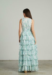 Vestido maxi floral en azul claro y verde, con una falda acampanada de volantes y un diseño sin mangas, con un corsé ajustado y cremallera en la parte posterior.
