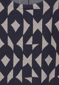 Bavlněná tkanina s geometrickým vzorem zahrnujícím diamantové a trojúhelníkové tvary na krémovém pozadí s tmavě námořnickou modří. Měkká textura, kulatý výstřih.