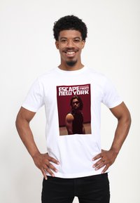 Hvid bomulds-T-shirt med et trykt billede fra "Escape from New York" med en rød baggrund, sorte detaljer og fed tekst.