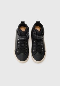 Sorte høyhælte sneakers laget av lær og stoff, med en skinnende svart overdel, snøring, sidelås og gummisåle. Geox-merket er til stede.