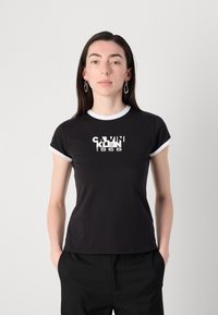 Black t-shirt with white trim at the collar and sleeves, featuring a bold "CALVIN KLEIN 1968" graphic centered on the front.