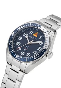 Roestvrijstalen horloge met een marineblauwe wijzerplaat, gedurfde witte cijfers en een zilveren band. Bevat een kompasontwerp en rode accenten.