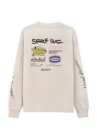 Jasno beżowa koszula z długim rękawem, ozdobiona graficznymi nadrukami w różnych kolorach i stylach na plecach oraz rękawach, z ściągaczami na mankietach.