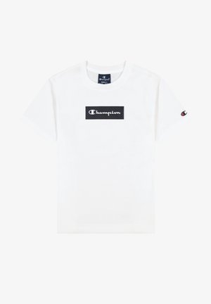 T-shirt blanc à manches courtes Champion avec un logo rectangulaire noir et un texte blanc sur la poitrine, ainsi qu'un petit logo sur la manche gauche.