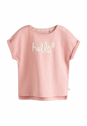 Rosa bomullströja med rundad halsringning, korta ärmar och vit text "hej" med blomsteraccent. Mjuk textur, avslappnad passform.