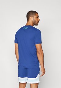 Tricou albastru cu mânecă scurtă, cu un finisaj texturat și un mic logo e59 pe spate; asortat cu pantaloni scurți albaștri cu accente albe și bleu deschis.