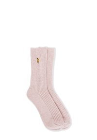 Un paio di calzini rosa a coste con un piccolo fiore giallo ricamato sulla caviglia, adagiati su uno sfondo bianco.