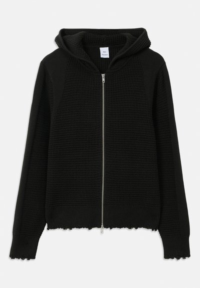 Hoodie zippé noir en tricot avec un tissu texturé, comprenant une capuche, un ourlet côtelé et des accents effilochés aux poignets et en bas.