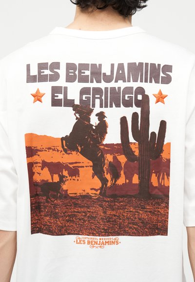 Καουμπόι επάνω σε ανεβασμένο άλογο με βοοειδή και έναν μεγάλο κάκτο σε έρημο τοπίο, το κείμενο αναγράφει «Les Benjamins El Gringo.»