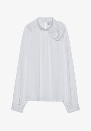 Blusa bianca a maniche lunghe con scollatura rotonda, dettaglio a chiave sulla schiena e una rosa decorativa in tessuto sulla spalla sinistra. Materiale morbido e leggero.