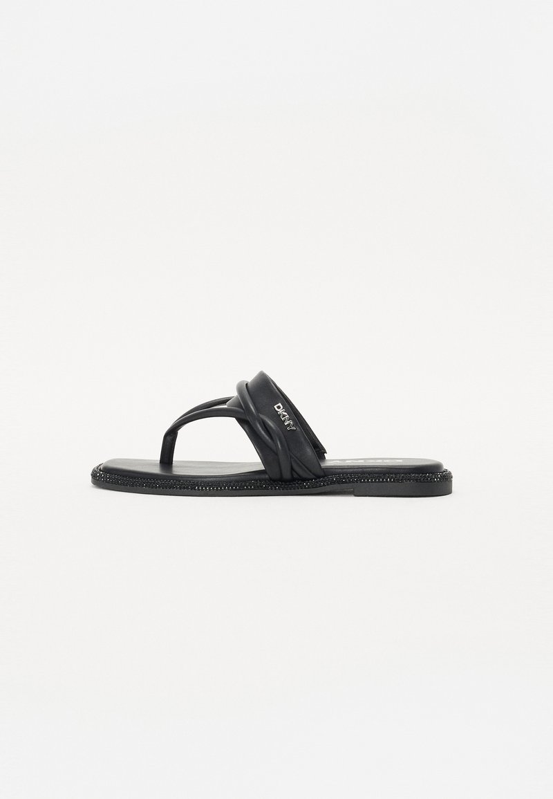 Melnas sandales ar plakanu zoli, ar krustveida siksnām atbalstam un teksturētu malu detaļu. Izgatavotas no elastīga materiāla.
