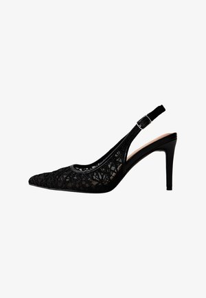 Zwarte slingback pumps met hoge hak, spits toelopende neus, bovenwerk van kant en verstelbare gesp op witte achtergrond.